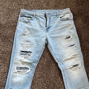 Distressed American Eagle athletic skinny men’s jeans in light blue wash.